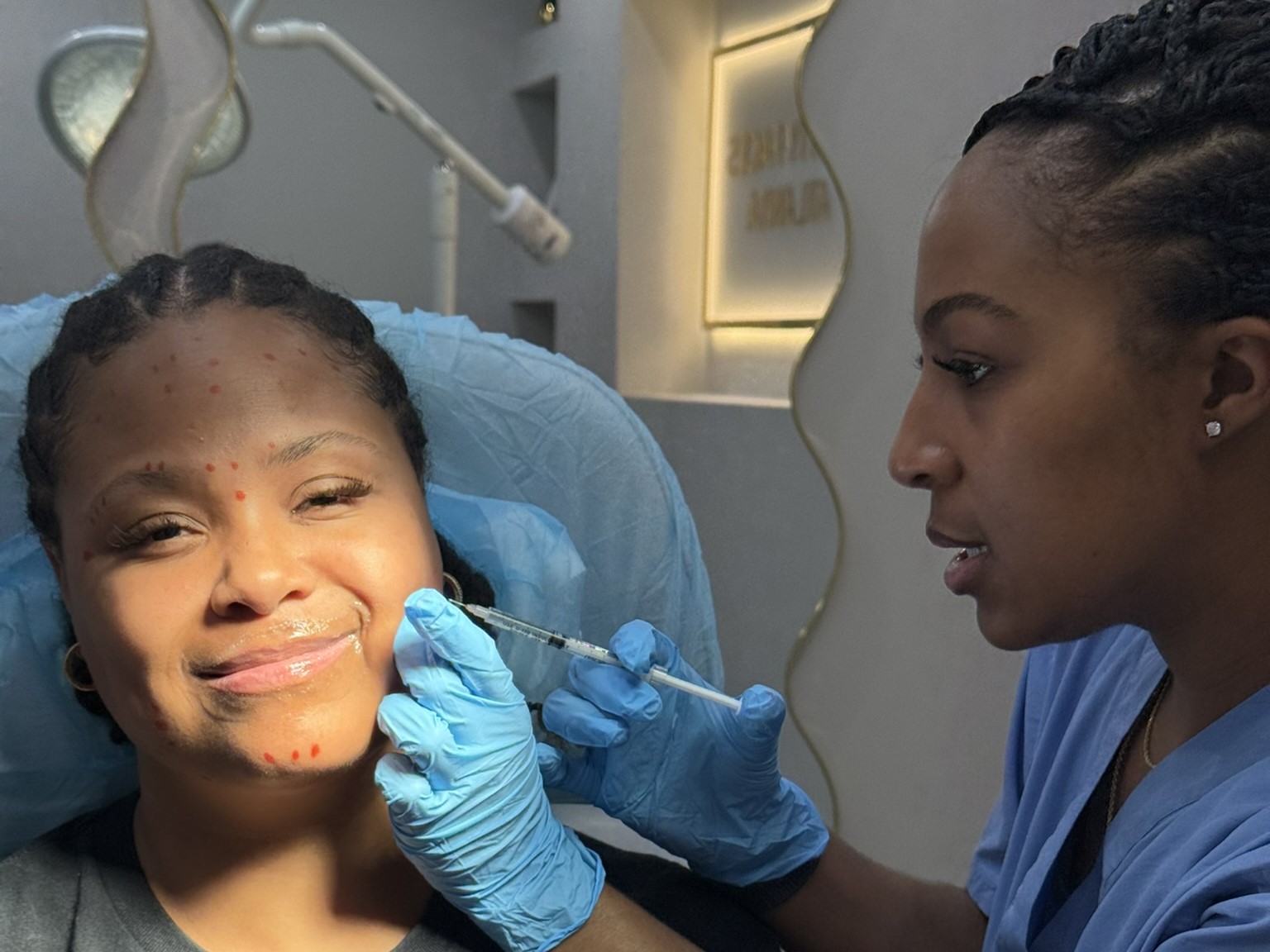 Dr. Nina Wyatt, MD MS injecting a patient's jawline with treatment points mapped across the chin and lower face at OMI Aesthetics in Smyrna, Georgia